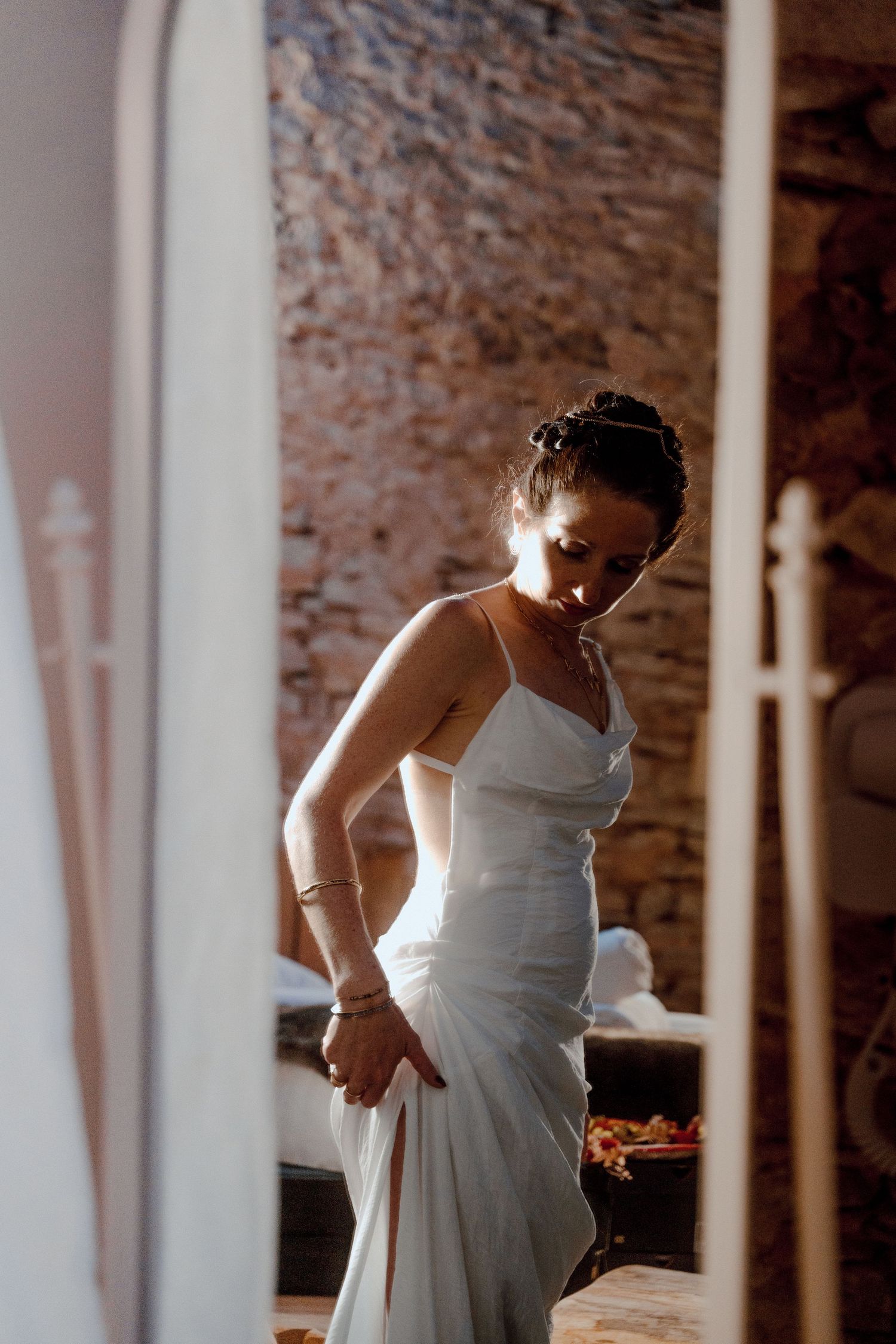 Une séquence montrant quelqu'un en train d'ajuster une robe de mariée blanche dans un lieu de style industriel.