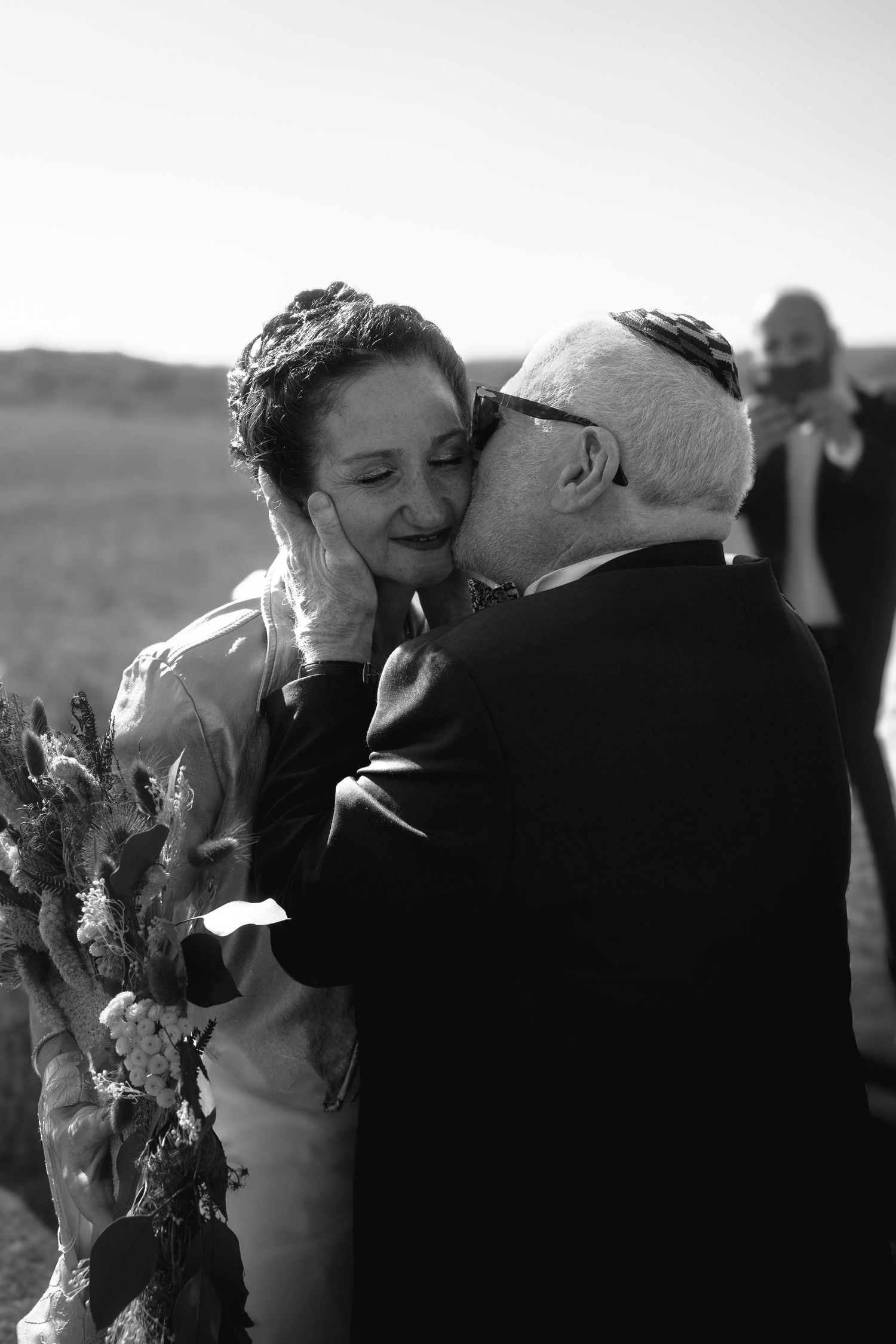 Une photo de mariage en noir et blanc capturant un moment icomplice entre la mariée et son père