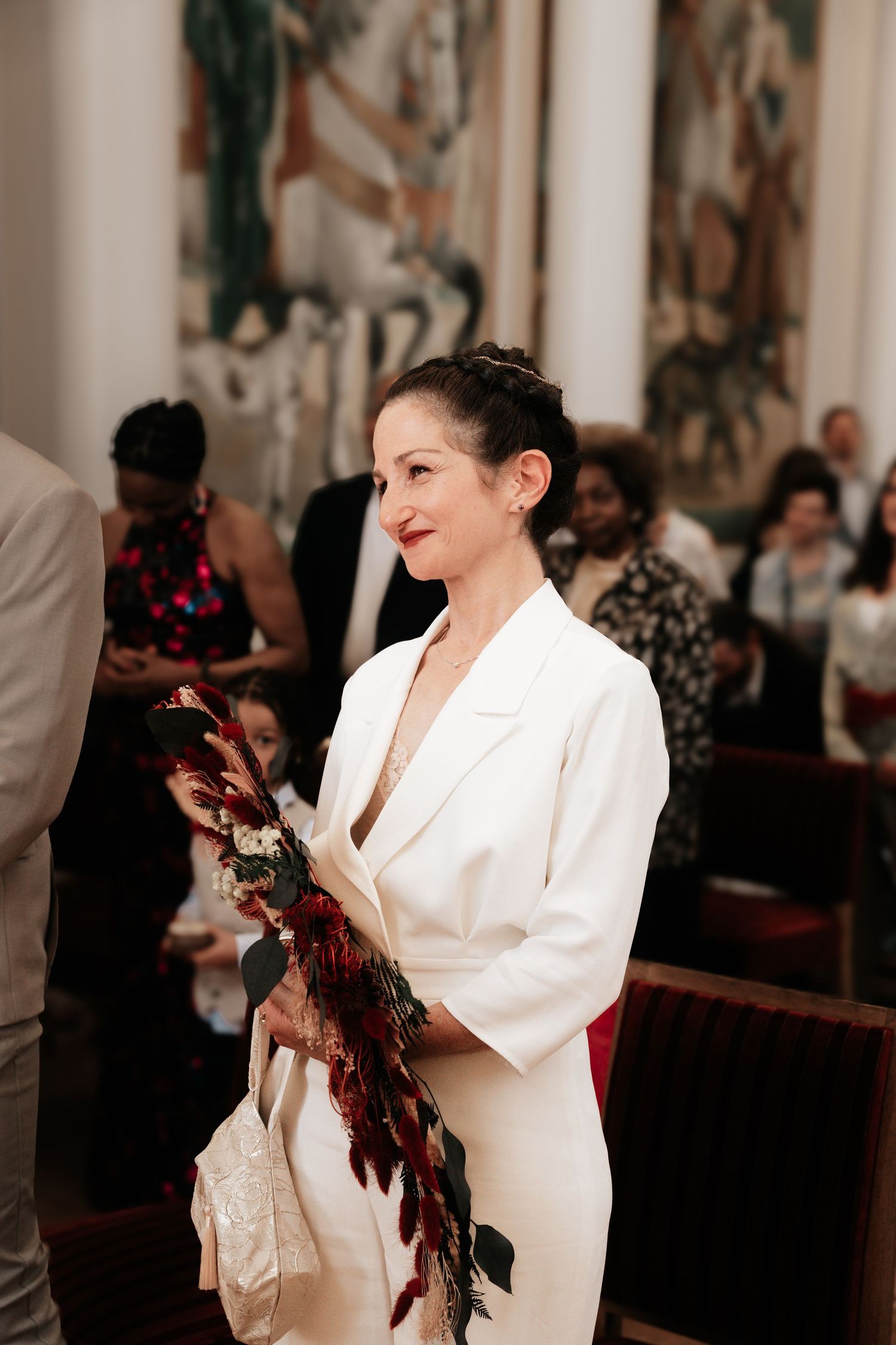 La mariée tient son bouquet de marié dans une mairie lors de ce qui semble être une cérémonie civile