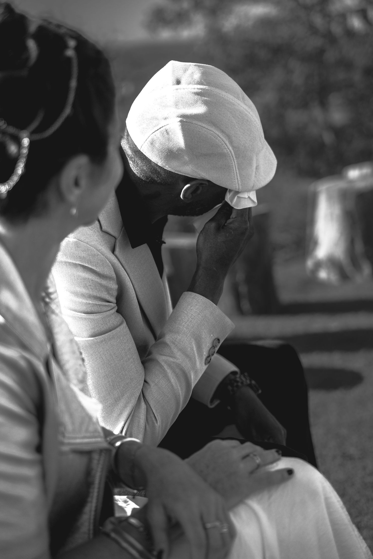 Une série de photos en noir et blanc montre le marié en veste blanche et chapeau.