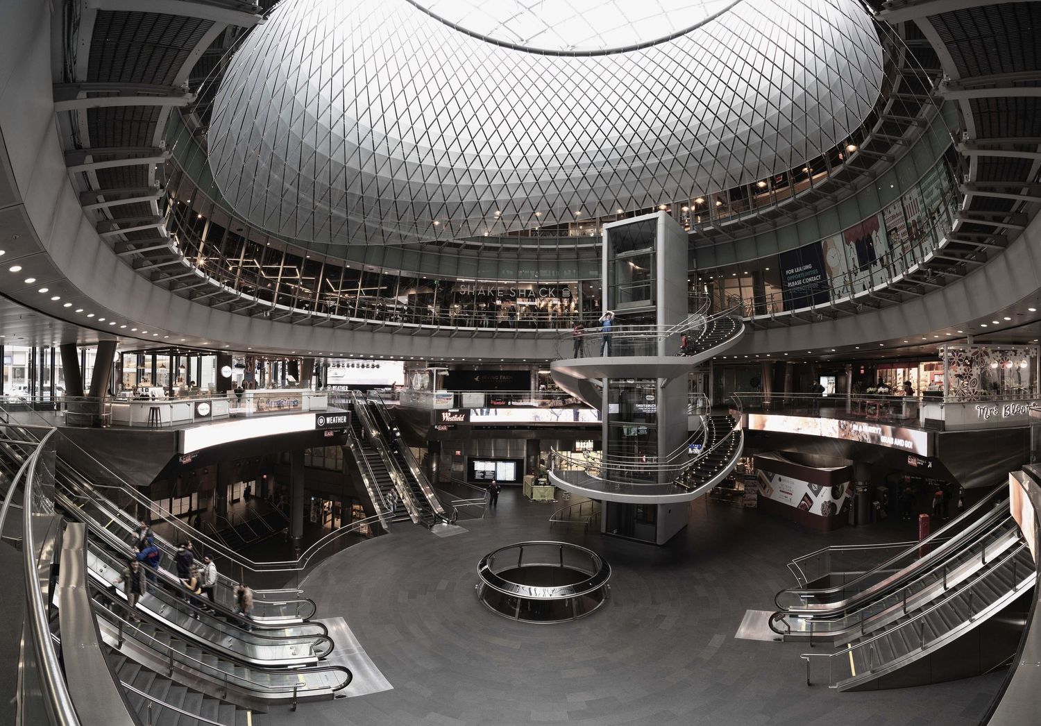 Manhattan Fulton Street Station with geometric dome ceiling, escalators and retail spaces.