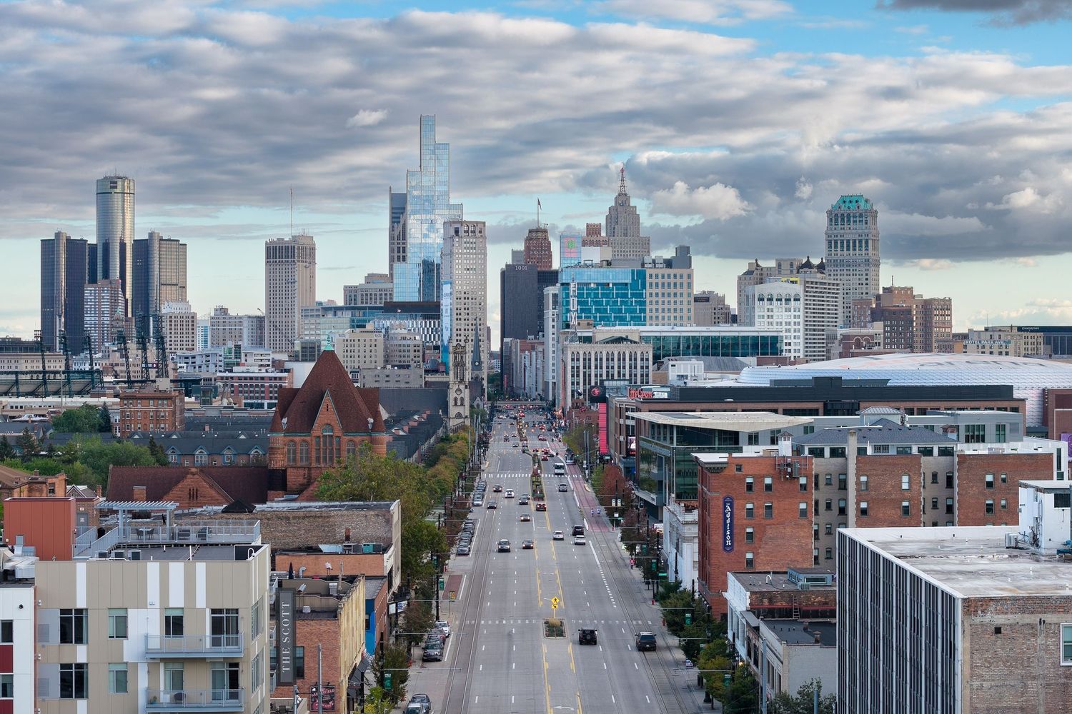 Panoramic aerial view of Montreal's downtown skyline with modern skyscrapers and historic buildings under cloudy skies.