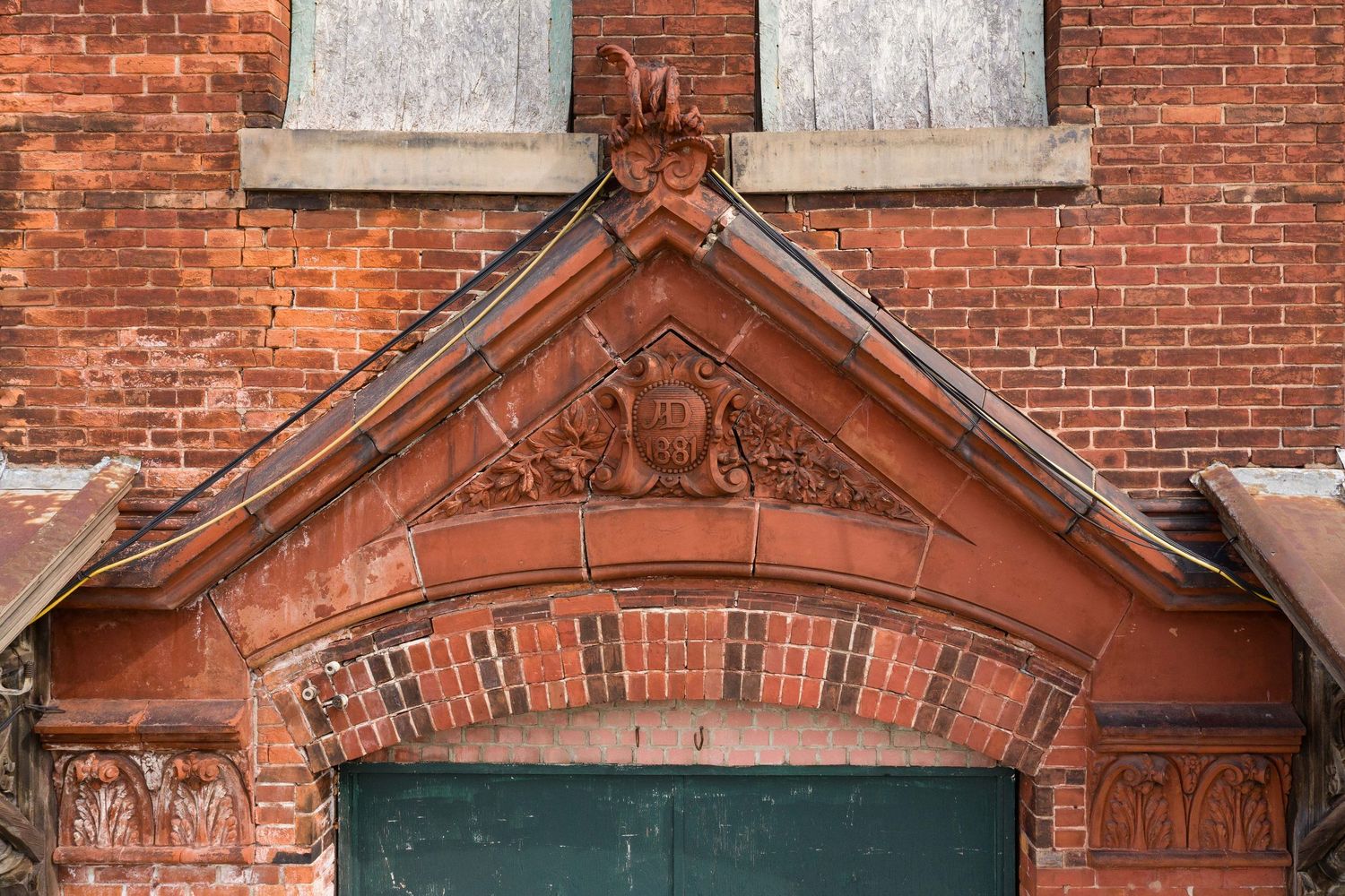 Ornate brick architectural details and decorative stonework at the Saginaw Potter Street Station AD 1881 escutcheon.