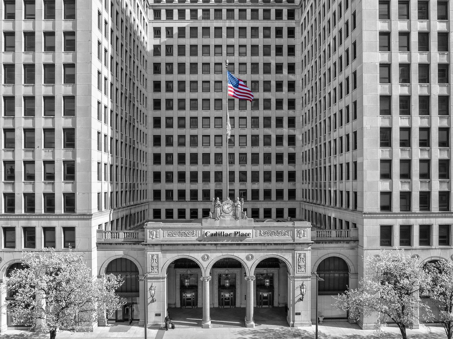 Cadillac Place art deco office building front exterior with flag in black and white in the New Center area of Detroit.