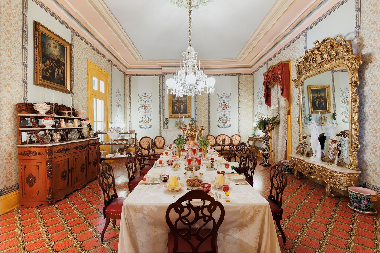 Elegant period room with crystal chandelier, ornate moldings, and antique furniture at the Belmont mansion in Nashville, Tennessee.