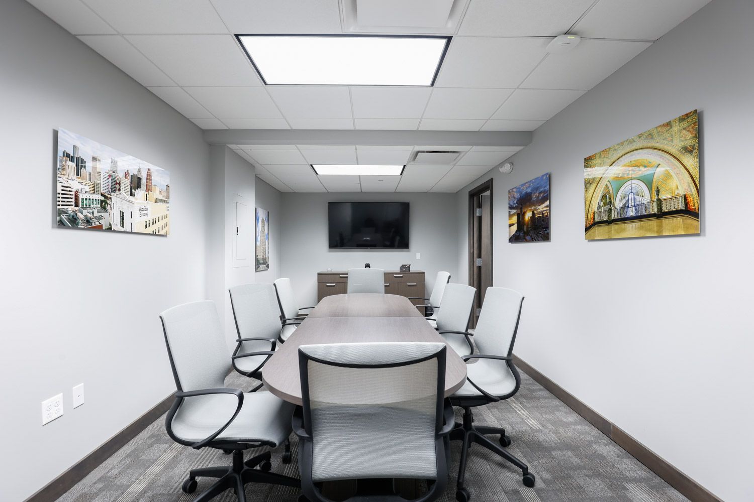 Modern office conference room with white chairs and framed photography of Detroit, Michigan on white walls.