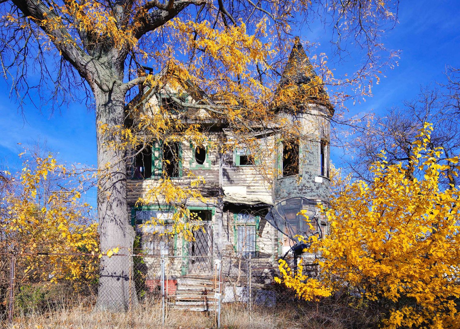 Fall foliage surrounds an abandoned castle-like home in Detroit, Michigan.