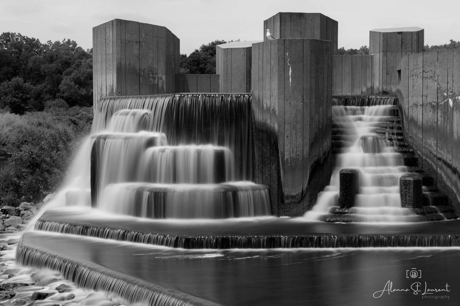 Monochrome image of a waterfall cascading down stepped concrete dam structure at the Flint Stepping Stone Falls.