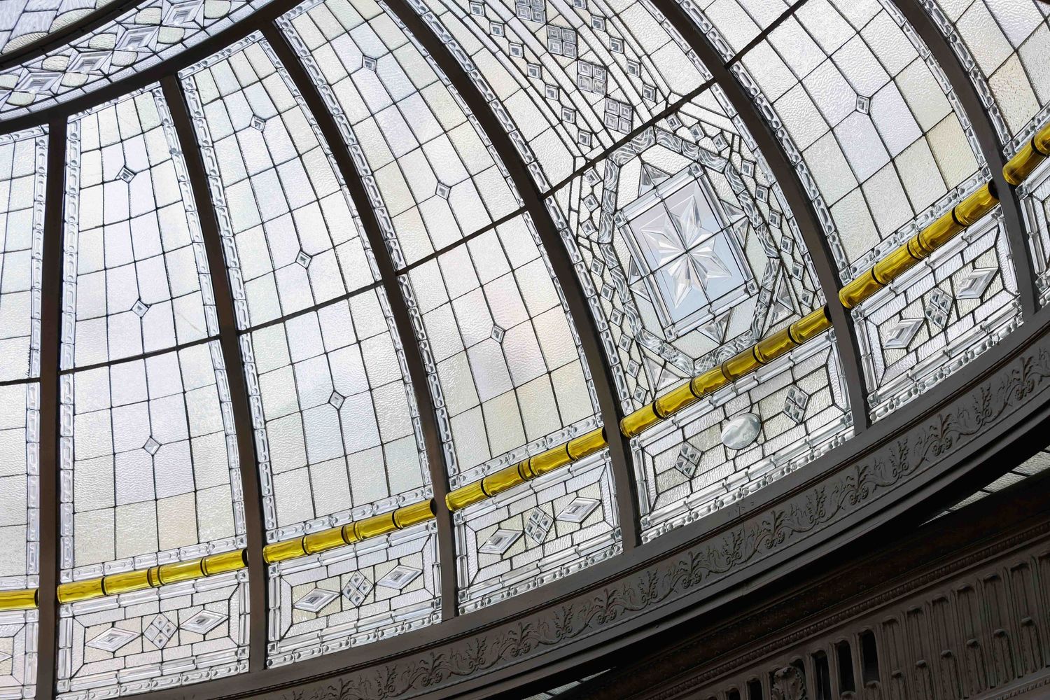 Geometric pattern of glass panels in a domed ceiling structure with metal framework in the Book Tower lobby in downtown Detroit, Michigan.