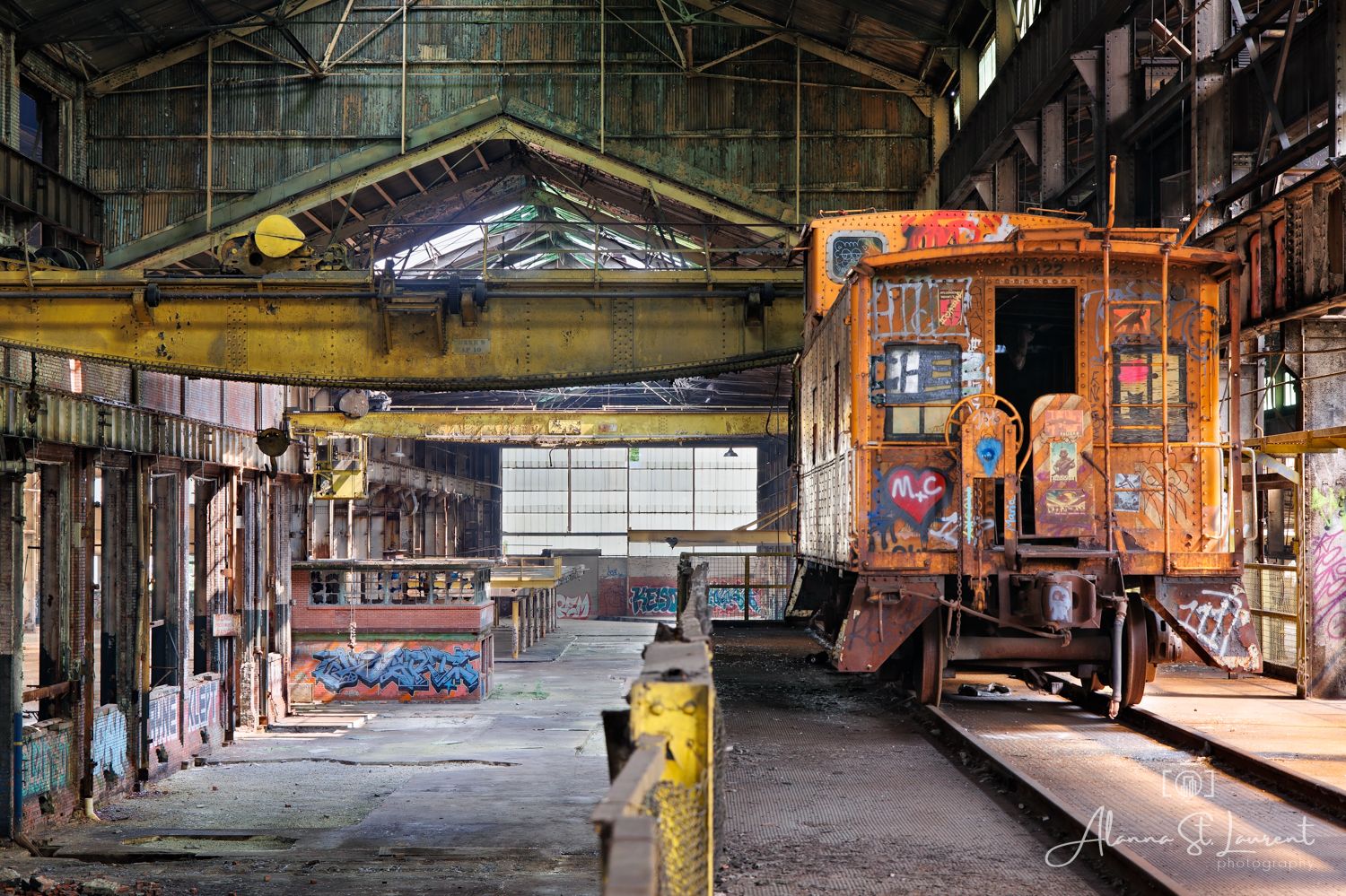 Panoramic view of an abandoned industrial warehouse interior with graffiti covered walls with an old train car in Cleveland Ohio.