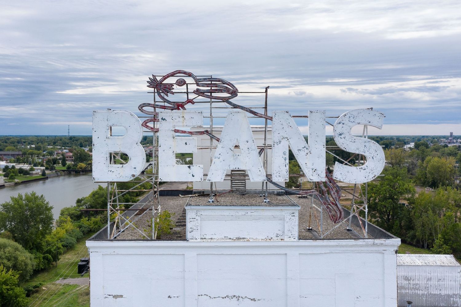 Closeup drone view of Michigan Bean Company's Bunny Beans Sign in Saginaw, Michigan against a cloudy sky.