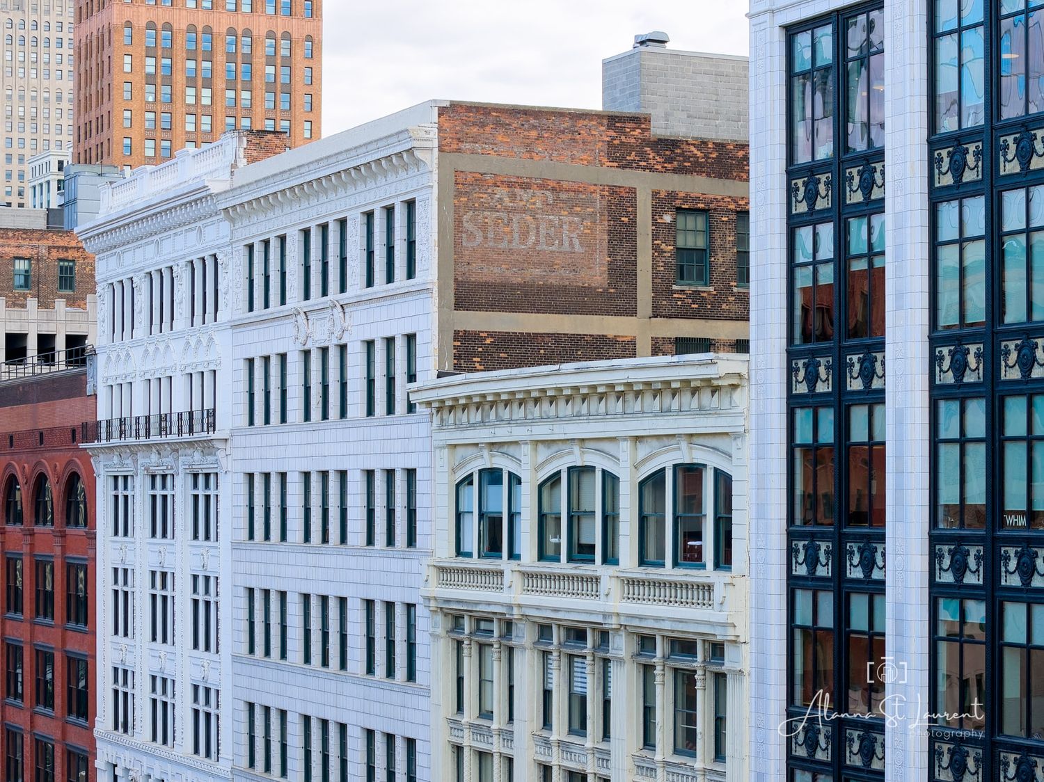 Historic urban building facades with ornate architecture and a vintage ghost sign in a downtown cityscape.