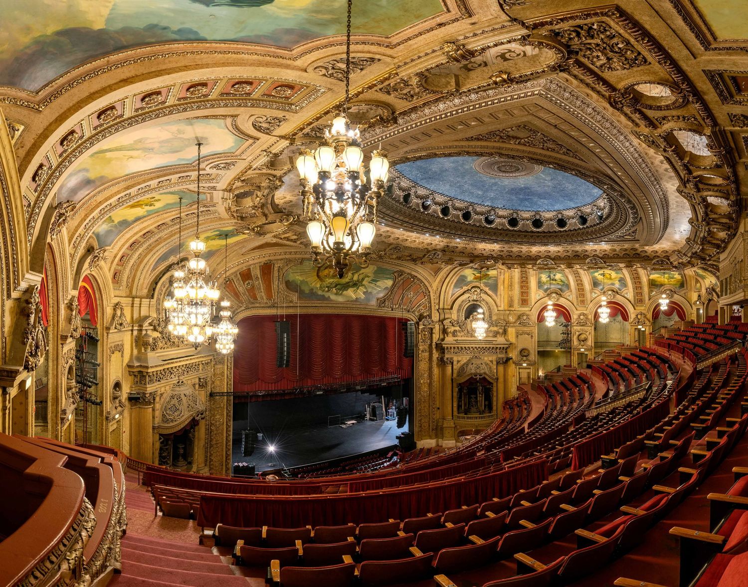 Chicago Theatre interior with golden details and chandeliers showing a panoramic view of the grand auditorium.