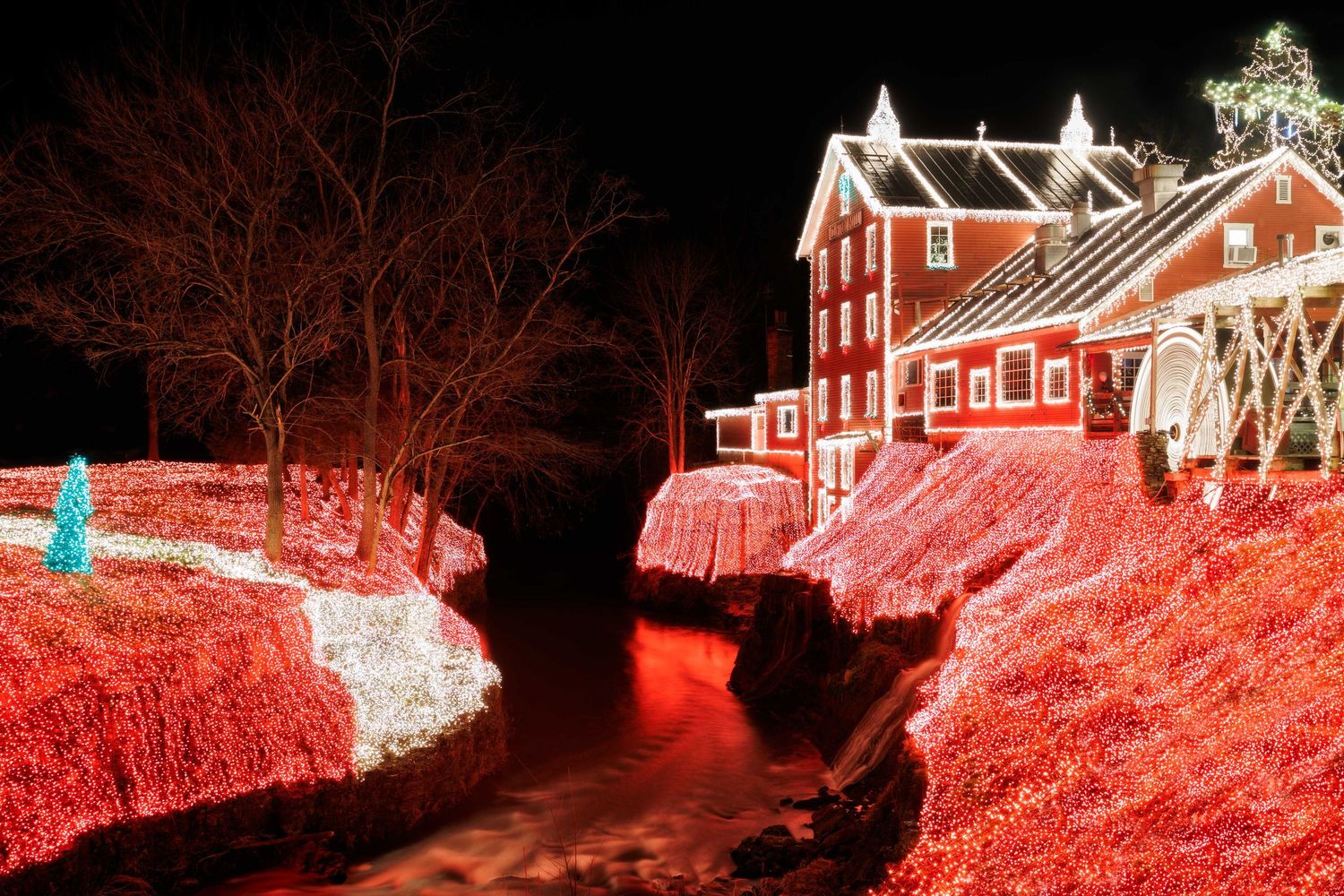 Holiday lights illuminate the Clifton Mill in Ohio along with festive red lights in a nighttime display along the Little Miami river.