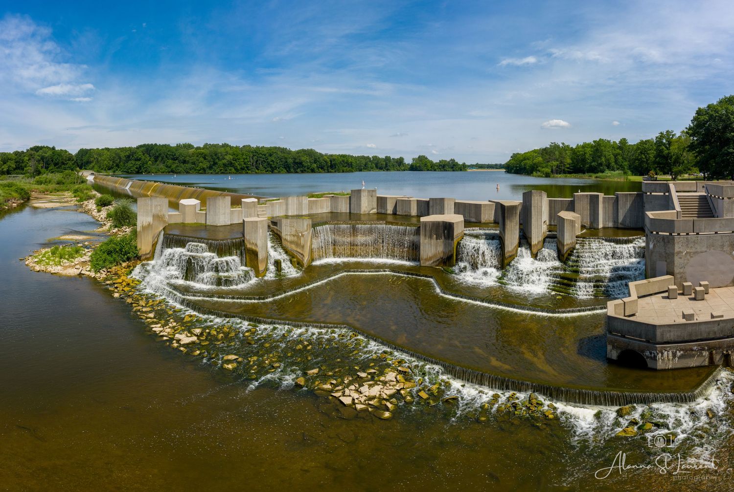 Modern dam with multiple waterfalls flowing over concrete barriers creating a dramatic waterscape at the Flint Stepping Stone Falls.