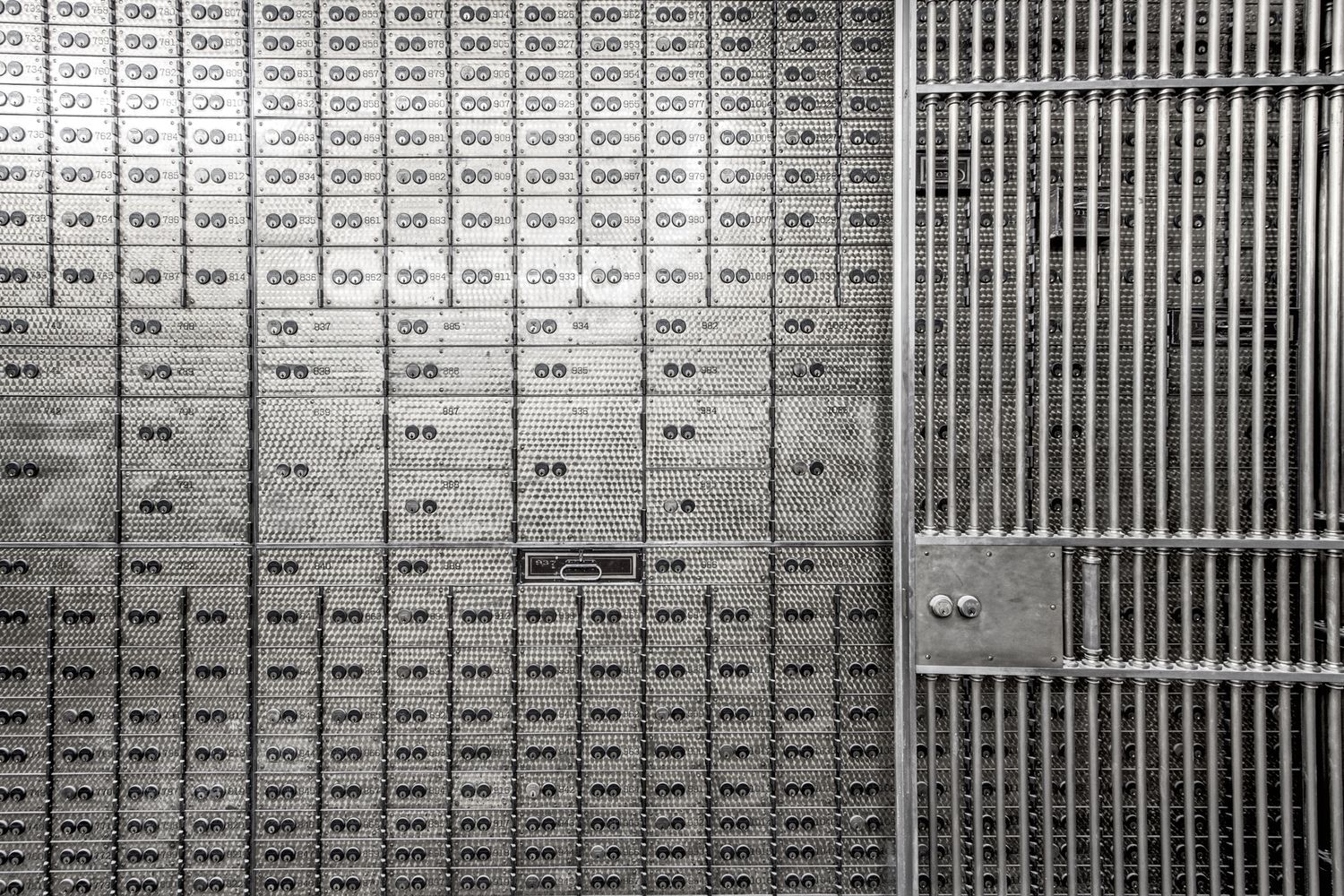 Row of vintage safety deposit boxes and a metal gate in an old bank vault. in the basement of the Chrysler House in Detroit, Michigan.