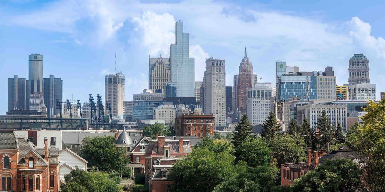 A panoramic view of Chicago's iconic skyline with tall skyscrapers reflecting sunlight against a clear blue sky.