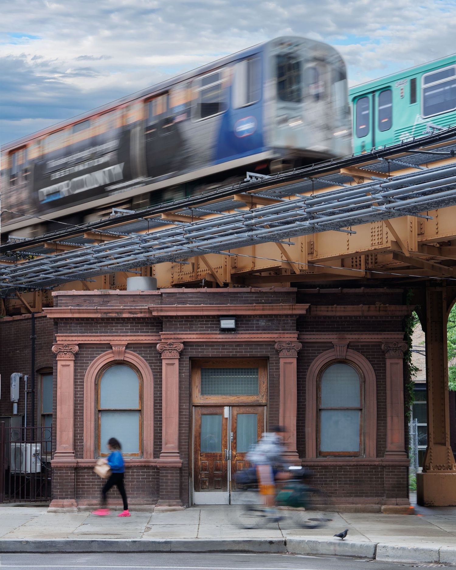Blurred motion of subway train passing through historic abandoned brick station below in Chicago, Illinois.