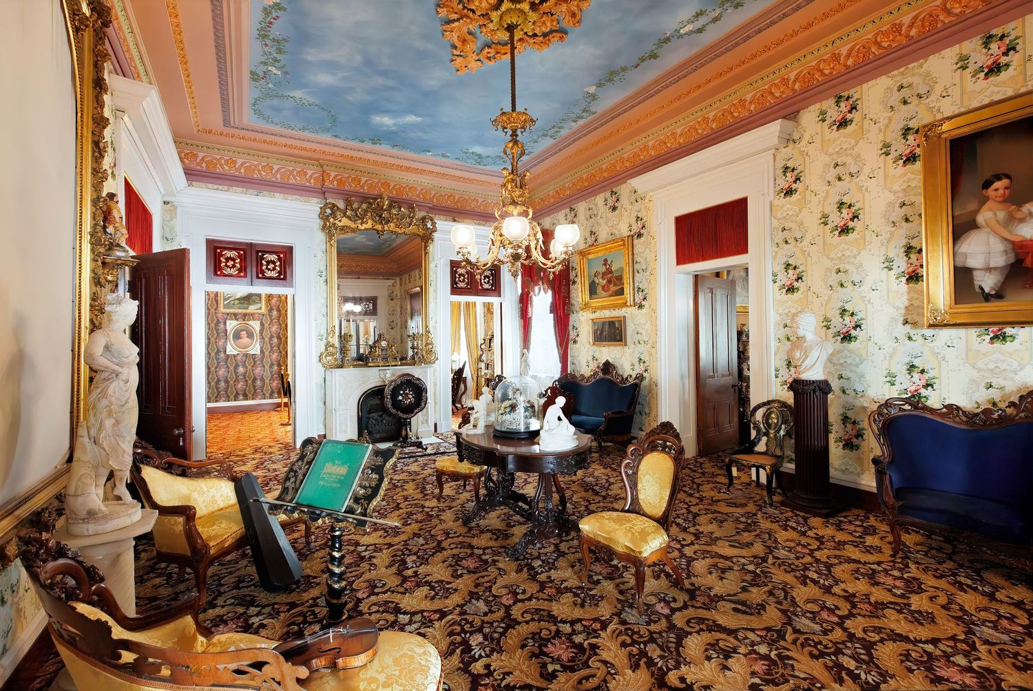 Victorian parlor with painted ceiling, ornate furniture, and decorative wall coverings at the Belmont mansion in Nashville, Tennessee.
