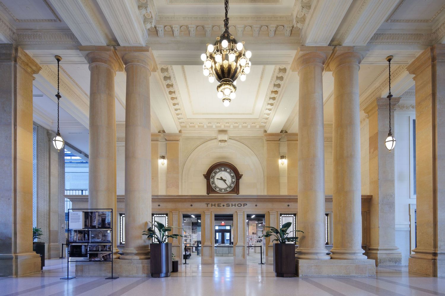 Elegant interior of the Michigan Train Station ticket window with tall columns, chandelier, and ornate architectural details.