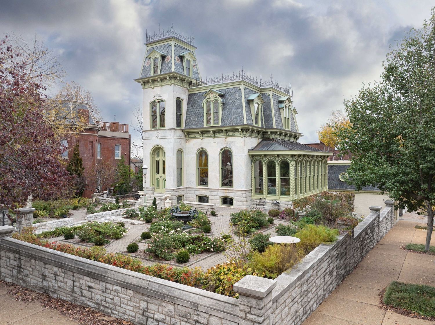 An ornate white Italianate mansion with a domed cupola surrounded by a walled garden in the Soulard neighborhood of St Louis Missouri.