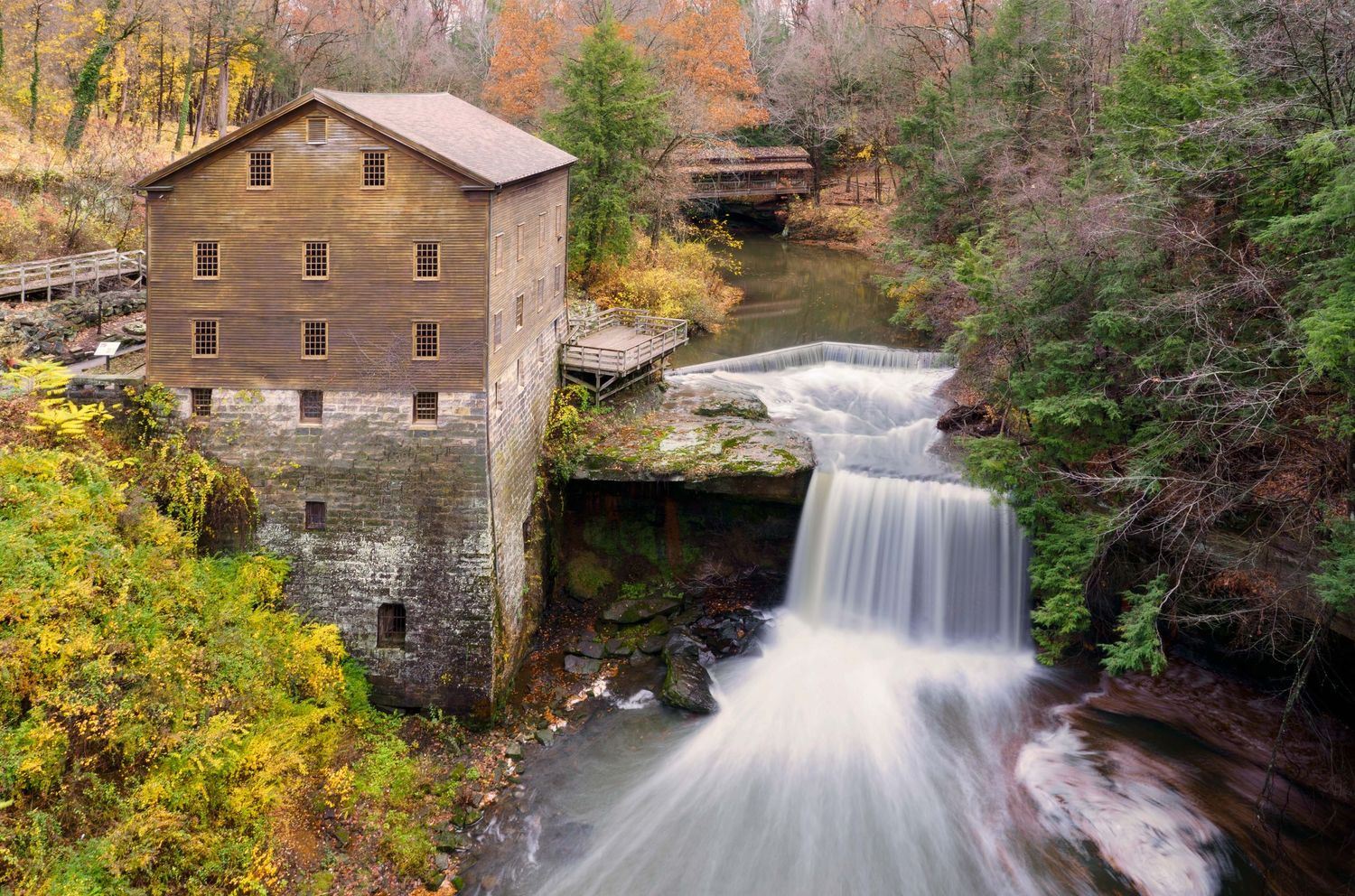 Historic Lanternman's Mill and waterfall surrounded by trees in Ohio.