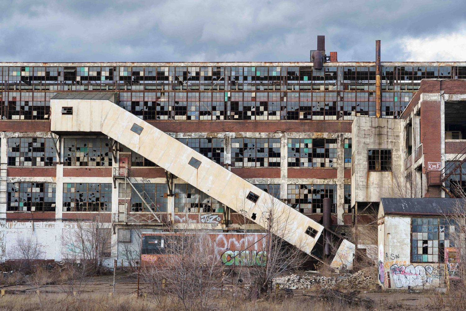 Exterior ramp on the abandoned Cadillac Stamping plant showing extensive structural damage and broken windows in Detroit, Michigan.