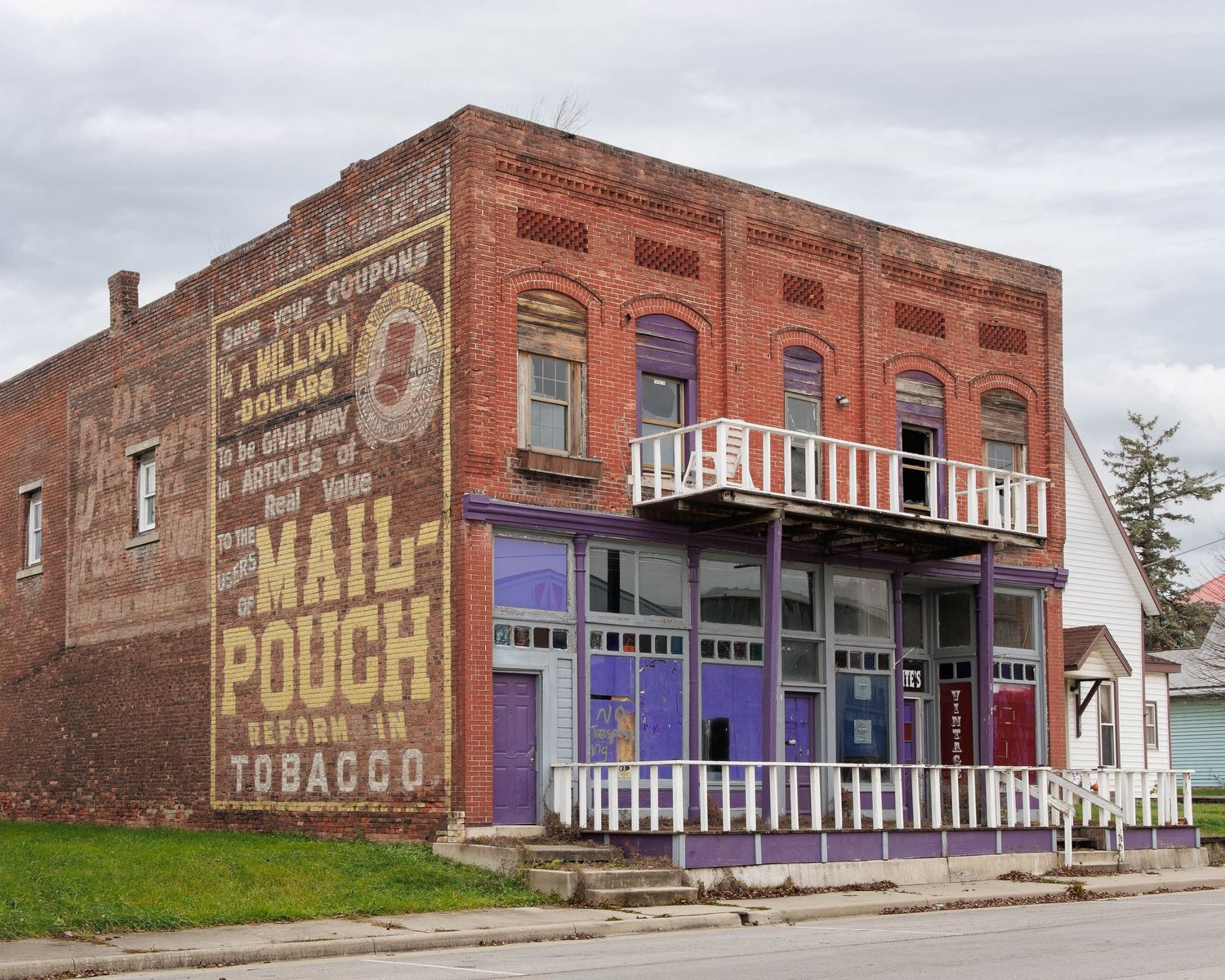 Red brick storefront with the Mail Pouch ghost sign vintage painted wall advertisements.