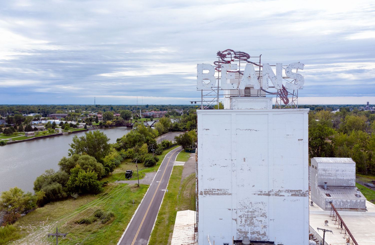 Wide drone view of Michigan Bean Company's Bunny Beans Sign in Saginaw, Michigan against a cloudy sky.