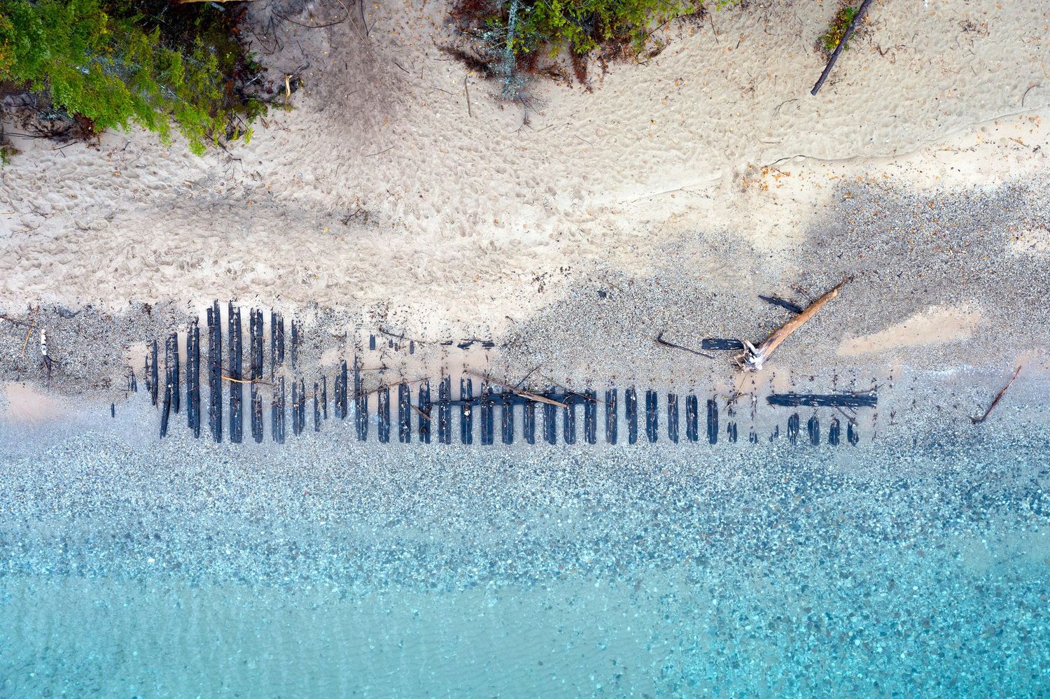 Aerial view of the Joseph S. Fay shipwreck on a Lake Huron beach with turquoise water meeting sandy white sand in Michigan.