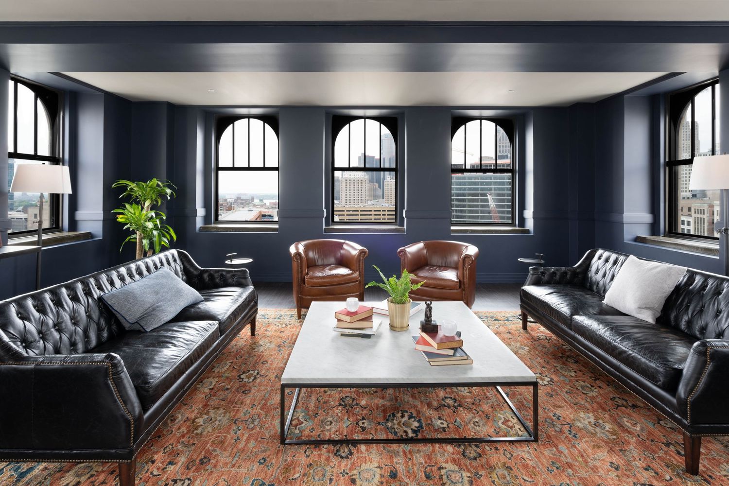 Modern lounge interior with dark walls and leather seating at the Monarch Club at the Element Hotel in downtown Detroit, Michigan.