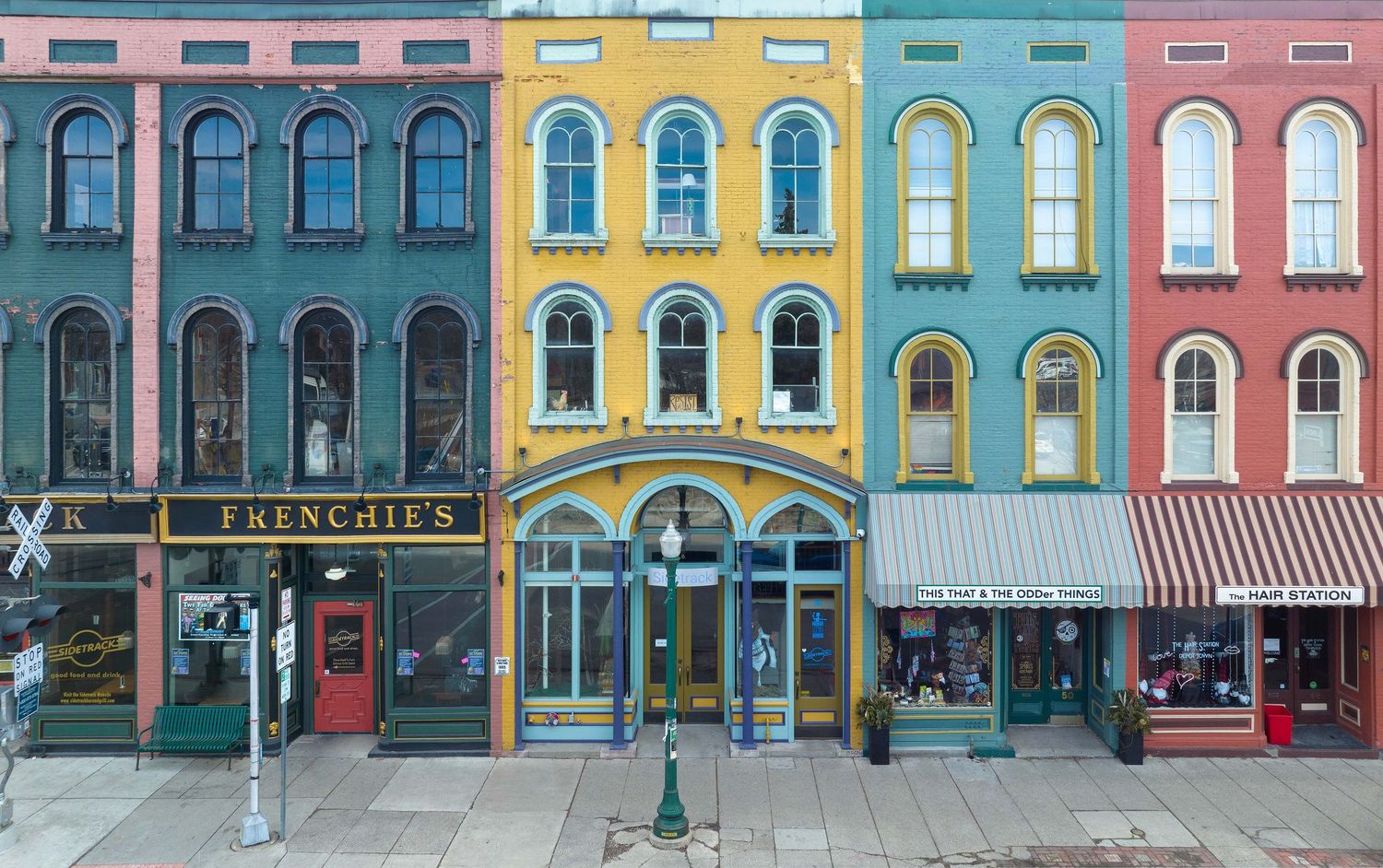 Colorful row of historic storefronts with pastel facades and arched windows in downtown Ypsilanti MIchigan captured with drone.