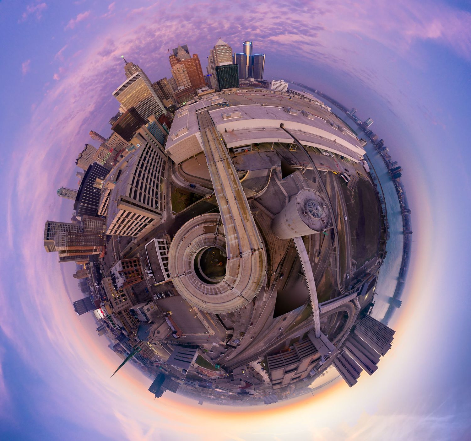 360-degree aerial drone panorama of downtown Detroit and the Cobo Hall parking ramp under a pink-purple sky.