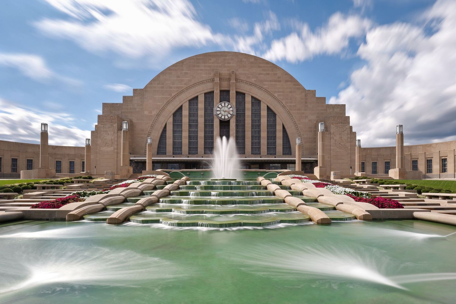 Union Terminal in Cincinnati Ohio with cascading fountain steps and water features and partly cloudy skies.