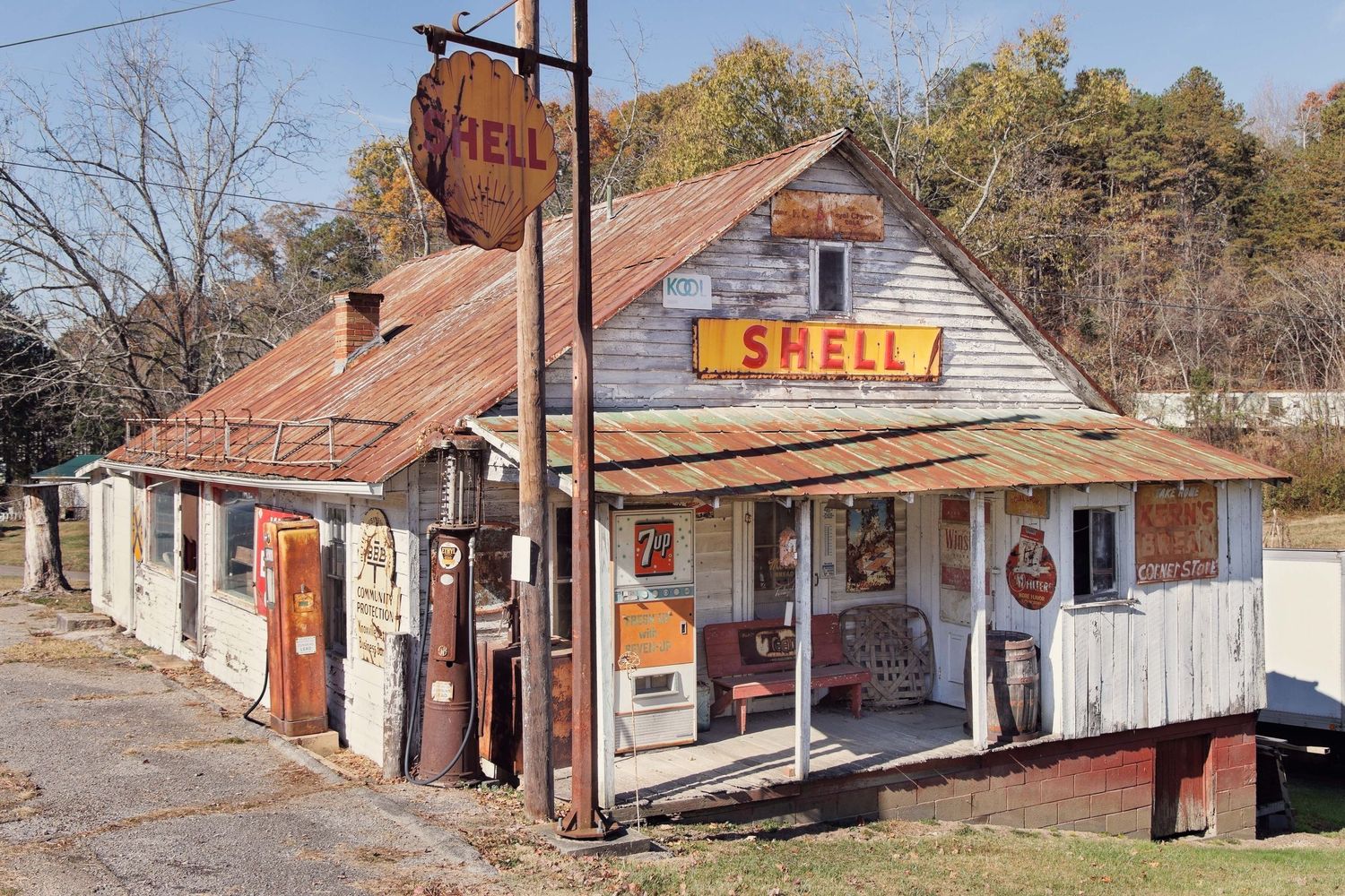 Abandoned rural gas station buildings with weathered wooden structures and rusty old signs in Tennessee.