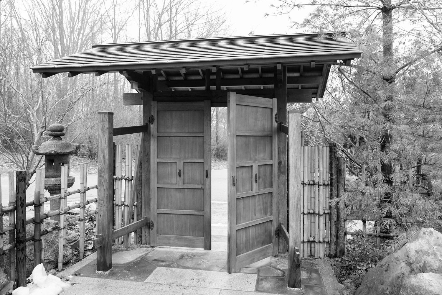 Traditional wooden Japanese garden gate with rustic architectural details at the Frederick Meijer Gardens in Grand Rapids, Michigan.