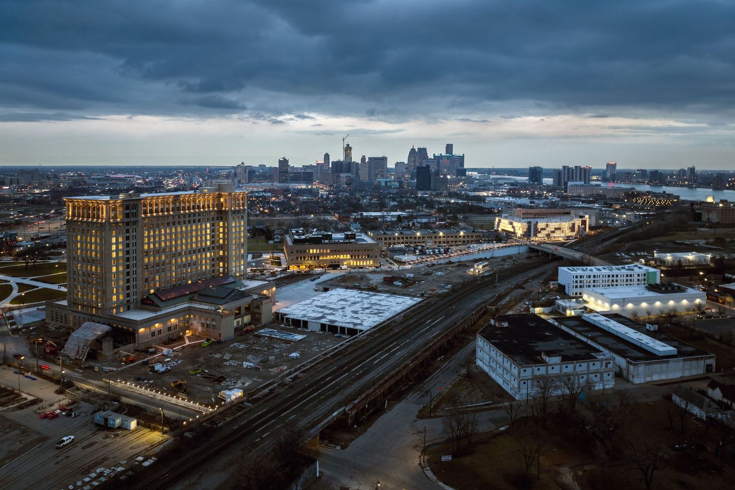 Dramatic panoramic cityscape under stormy skies showing the Michigan train station and the downtown Detroit skyline.
