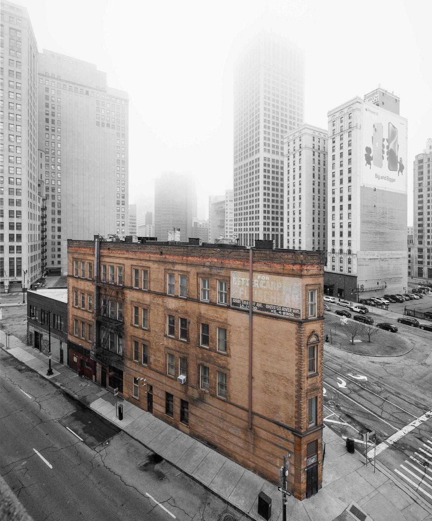Historic Reid building stands in contrast to modern skyscrapers on a foggy morning in downtown Detroit, Michigan.