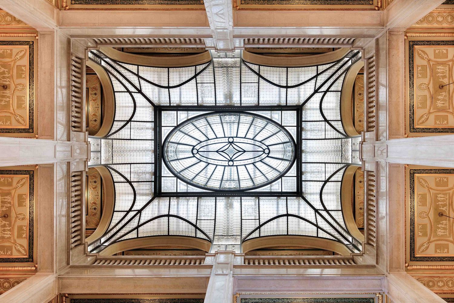 Looking up at the ornate glass ceiling with intricate metalwork in the Book Tower lobby in downtown Detroit, Michigan.