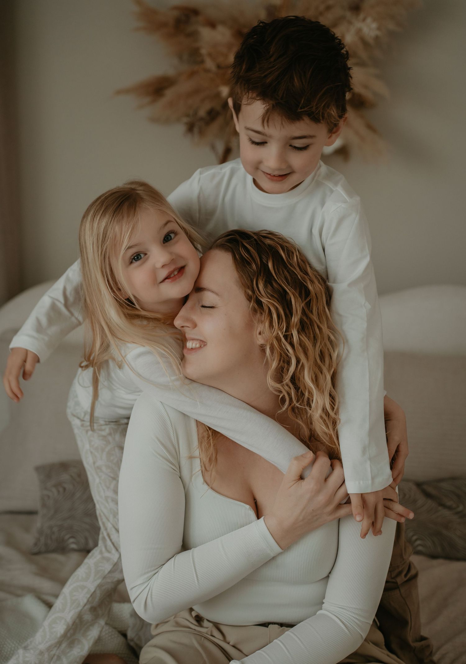 Liefdevol moment tijdens een gezinsshoot in Drenthe met moeder en kinderen in een lichte setting