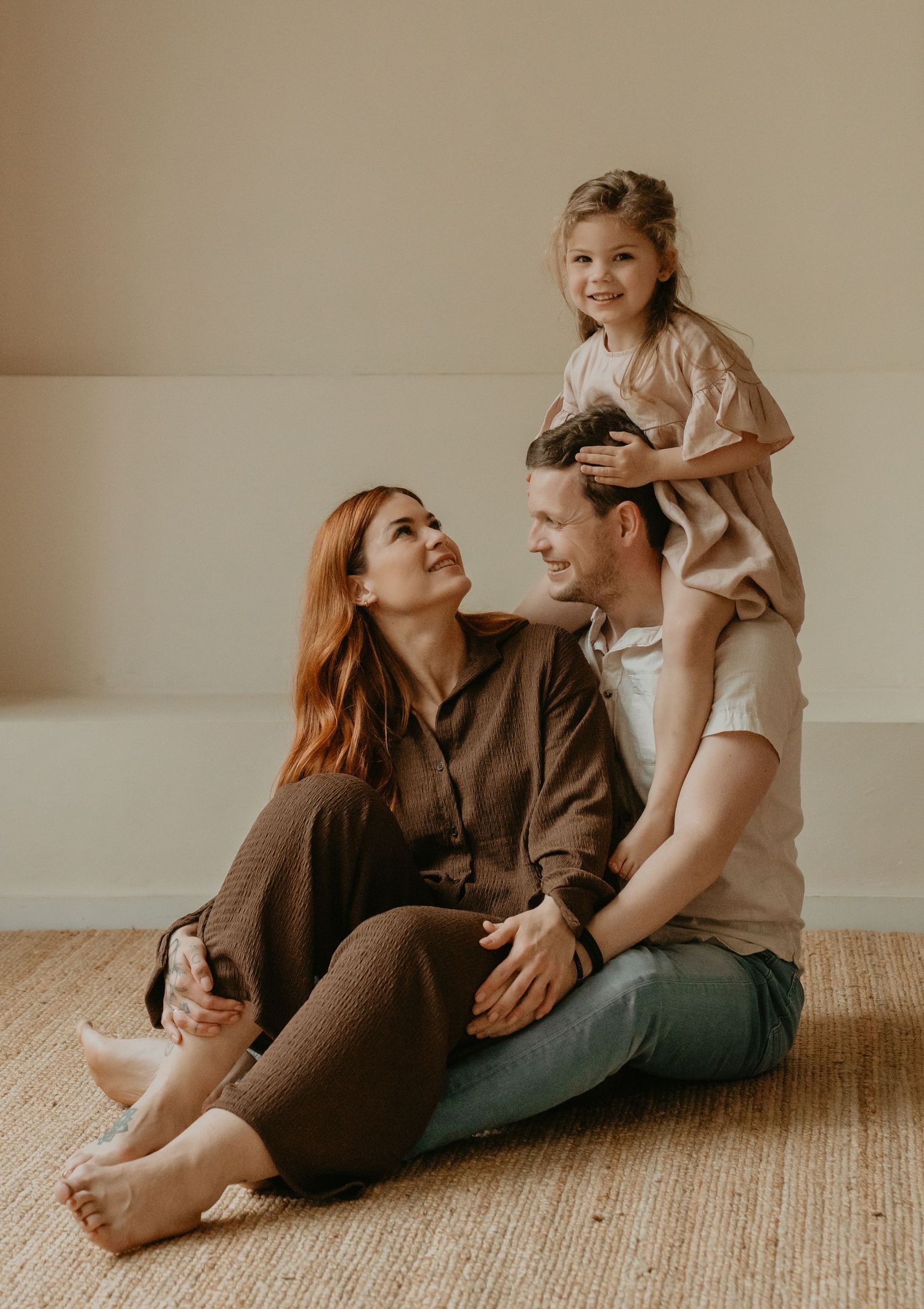 Liefdevol moment tijdens een gezinsshoot in Drenthe met ouders en kind in een rustige, lichte setting