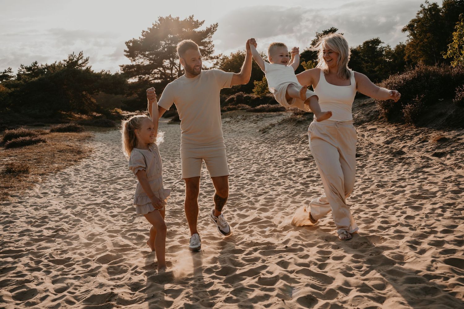 Spontane gezinsshoot in Drenthe buiten tijdens golden hour met spelende kinderen
