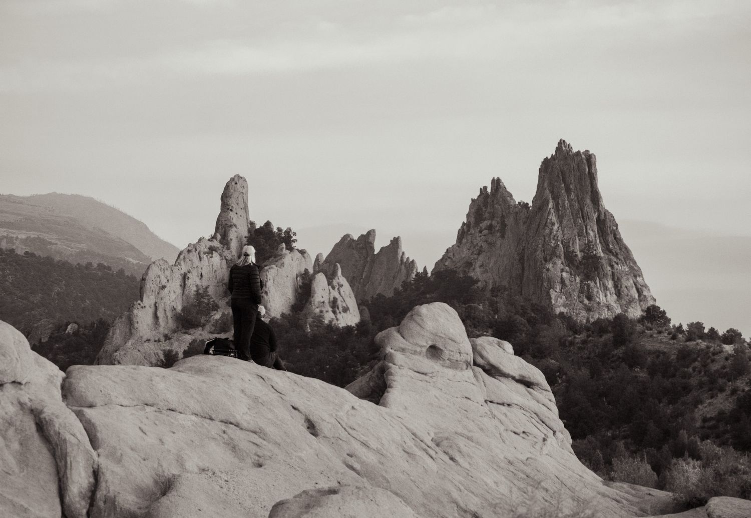 Dramatic black and white landscape of Garden of the Gods rock formations with jagged spires against cloudy sky.
