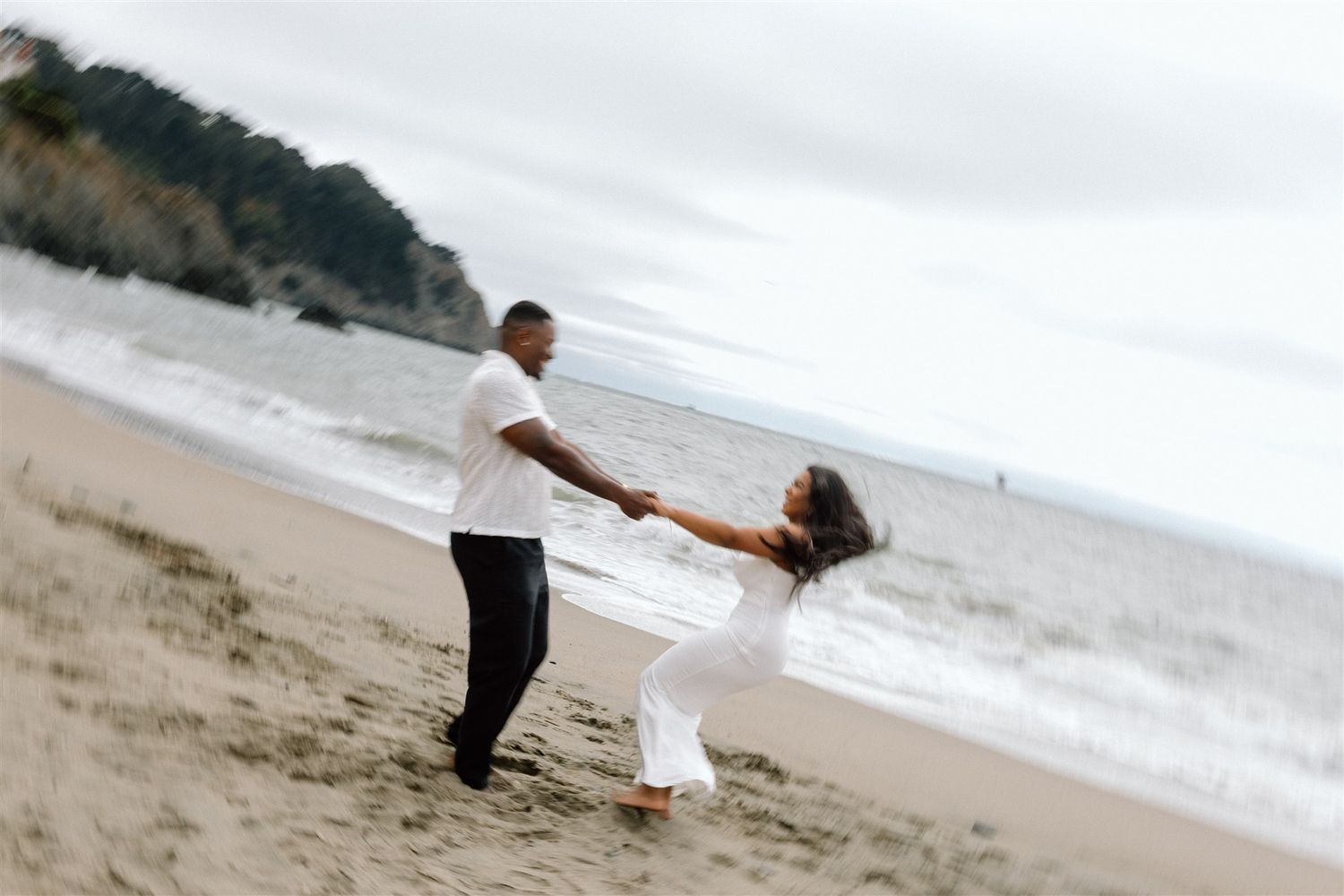 Couple posing for their engagement session at Baker Beach in San Francisco, California, captured by Makayla Miranda Photo
