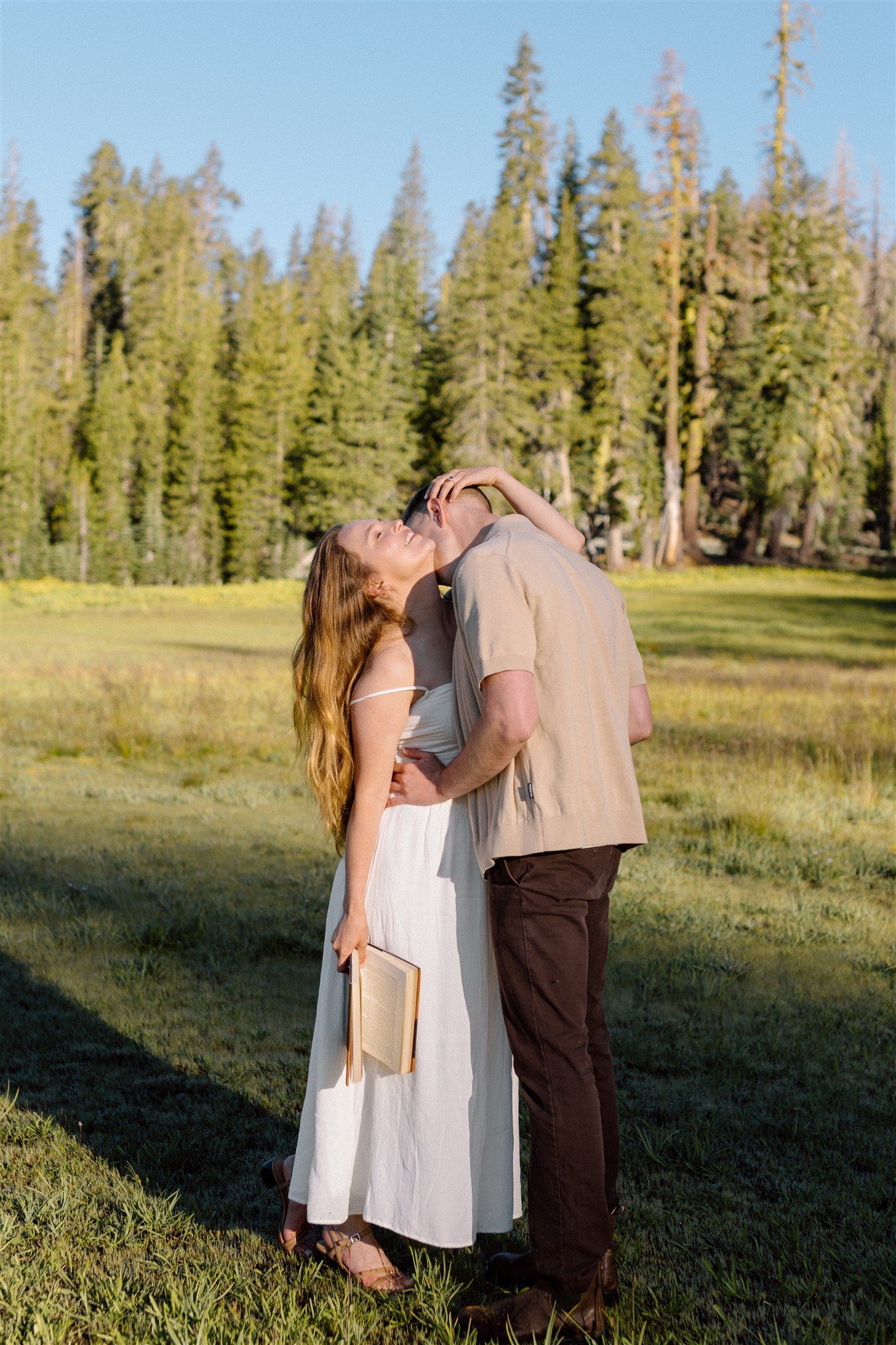 Couple posing for their engagement session in a meadow at Lassen Volcanic National Park in Northern California, captured by Makayla Miranda