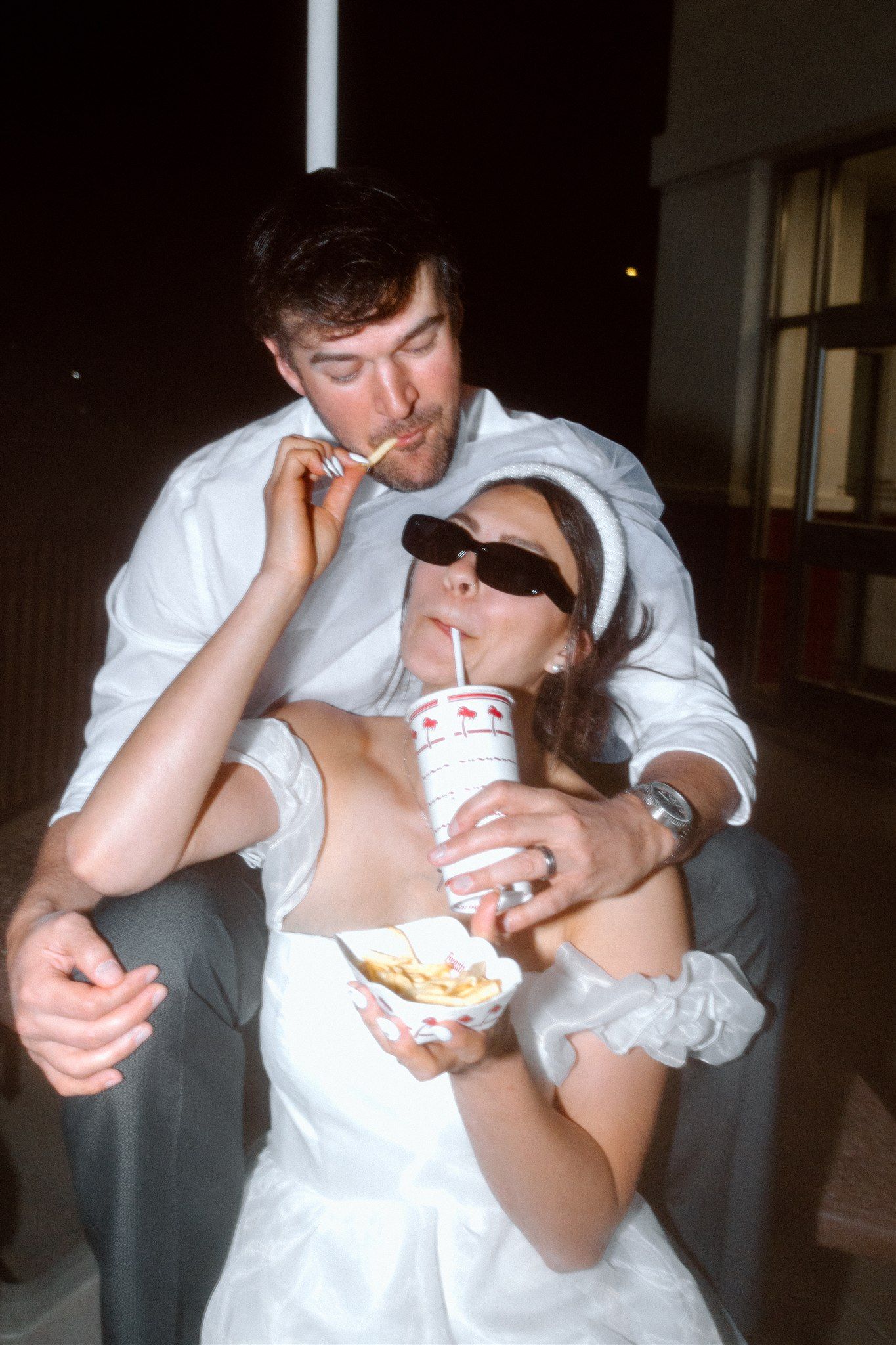 Couple feeding each other food during a styled elopement session at In-N-Out in California, captured by Makayla Miranda Photo.