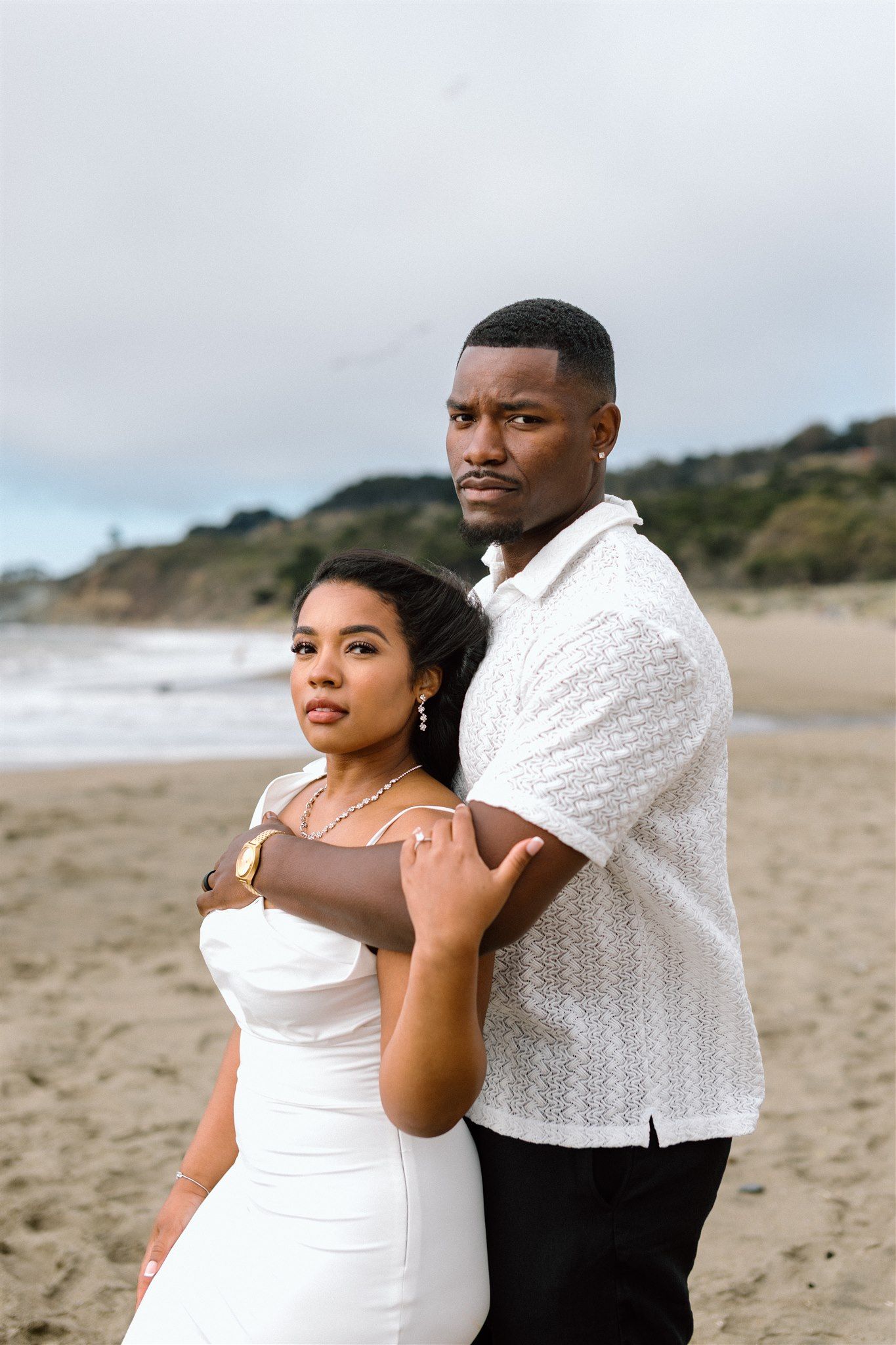 Couple posing for their engagement session at Baker Beach in San Francisco, California, captured by Makayla Miranda Photo