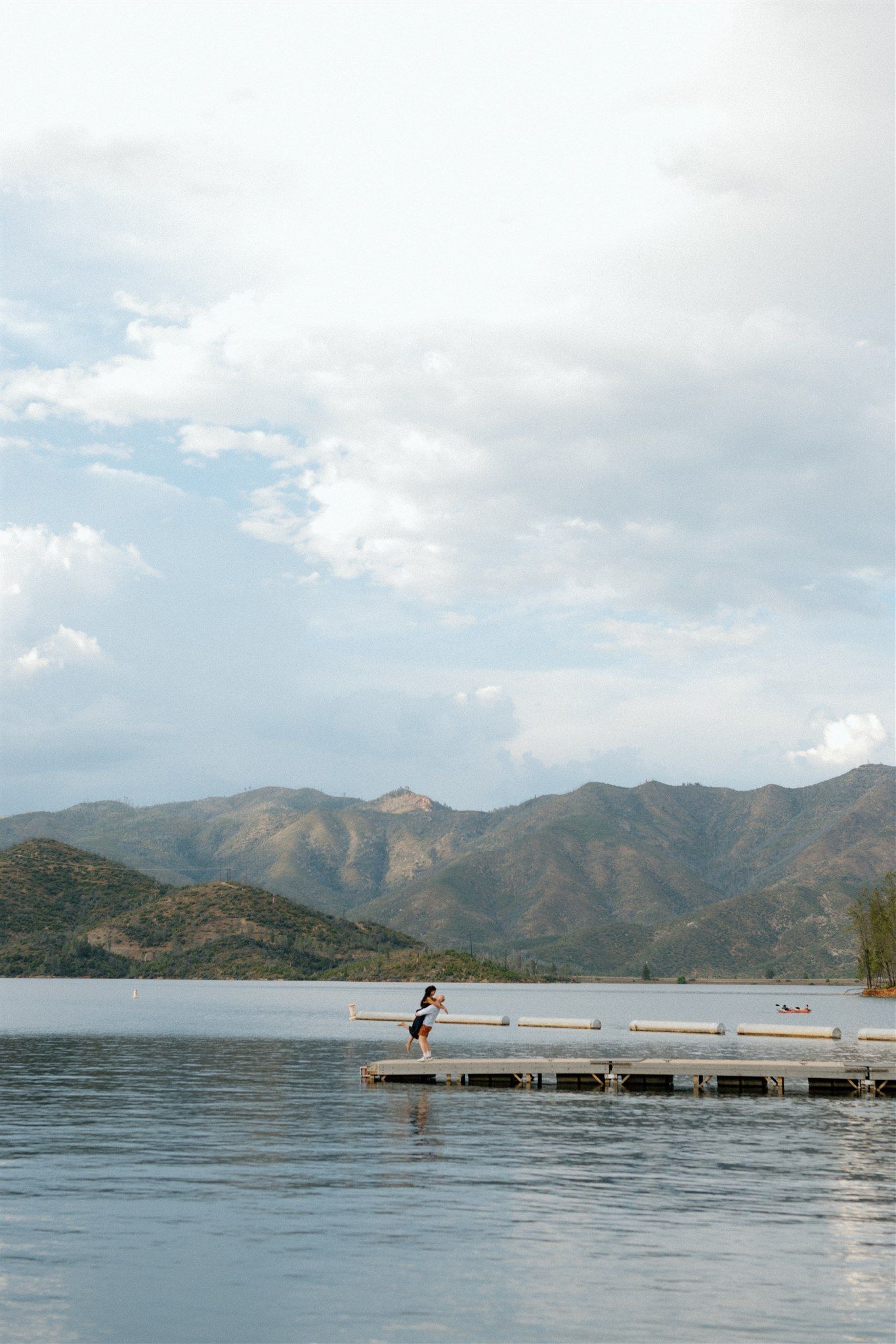 Couple posing on a dock in the middle of Whiskeytown Lake during their couples session, captured by Makayla Miranda Photo.