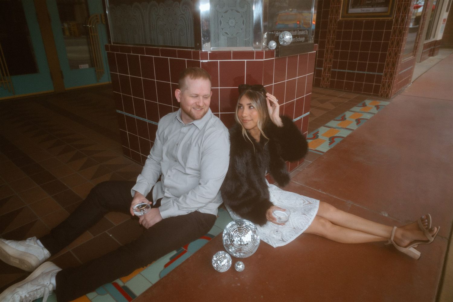 Couple posing for a styled engagement session in front of a theater, captured by Makayla Miranda Photo.