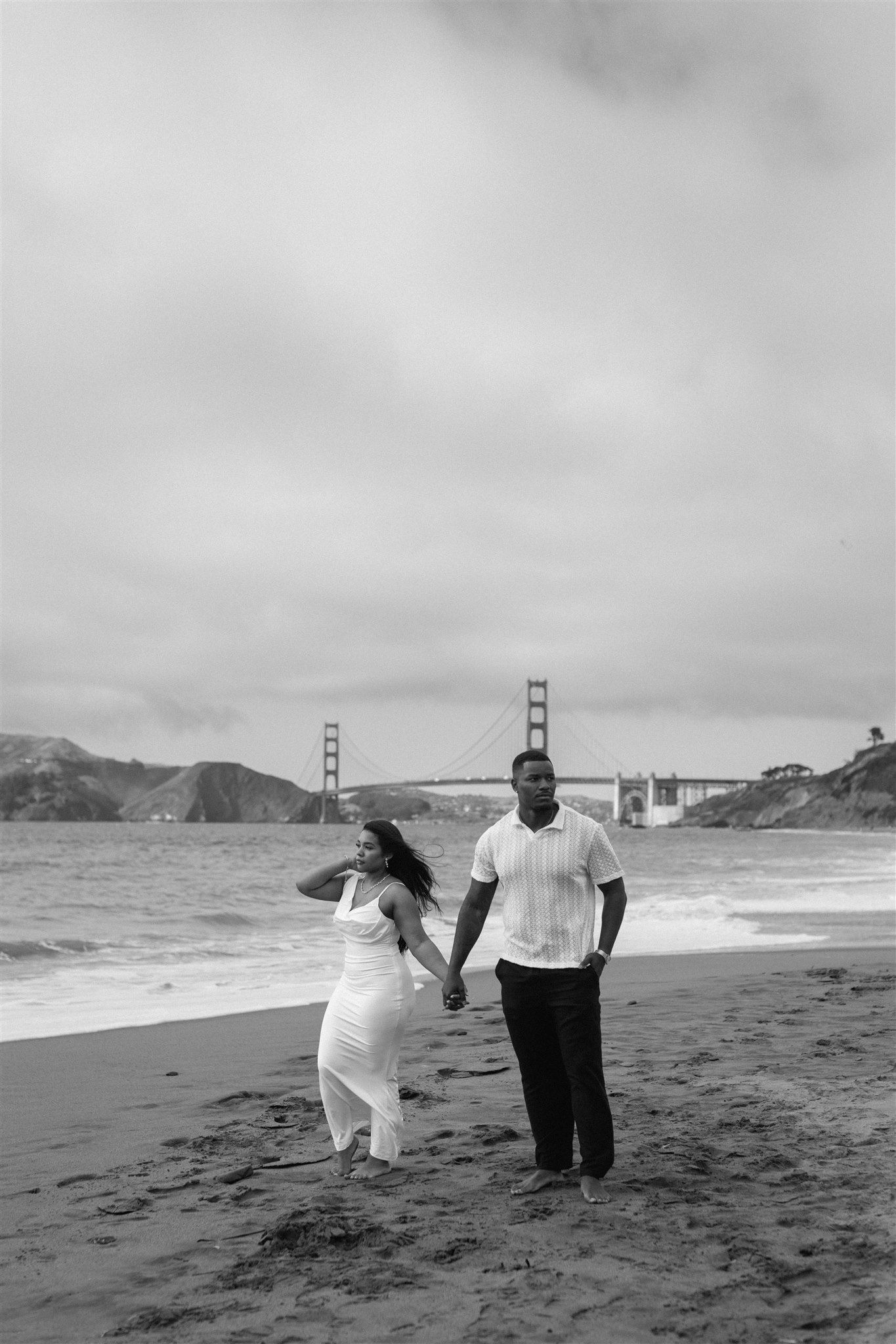 Couple posing for their engagement session at Baker Beach in San Francisco, California, captured by Makayla Miranda Photo